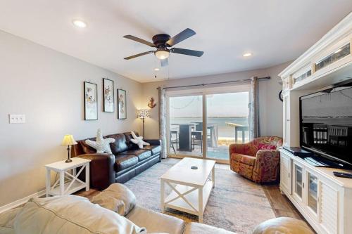 a living room with a couch and a flat screen tv at White Sands Bay Front Pensacola Condo in Pensacola Beach