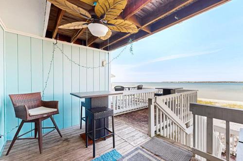 a porch with a table and chairs and the beach at White Sands Bay Front Pensacola Condo in Pensacola Beach