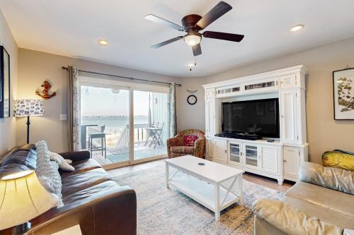 a living room with a couch and a flat screen tv at White Sands Bay Front Pensacola Condo in Pensacola Beach
