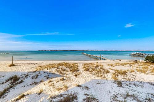 a beach with a pier and the ocean at White Sands Bay Front Pensacola Condo in Pensacola Beach