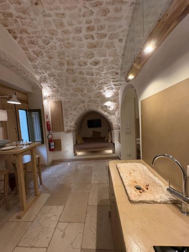 a kitchen with a sink and a room with a bed at Opera Prima - Luxury Homes in Ceglie Messapica