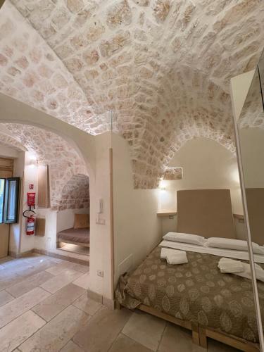 a bedroom with a bed and a stone ceiling at Opera Prima - Luxury Homes in Ceglie Messapica