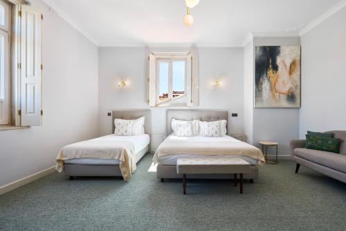a bedroom with two beds and a couch at Estoril Boutique Hotel - Adults Only in Estoril