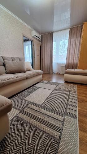 salon z kanapą i dywanem w obiekcie Квартира w mieście Bałchasz