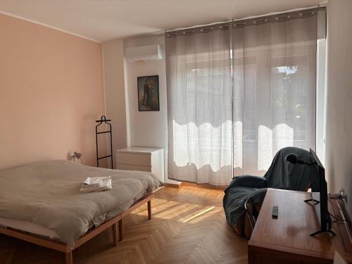 a bedroom with a bed and a large window at Bagaini Urban Flat in Varese