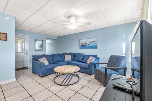 a living room with a blue couch and chairs at The Treehouse On the Bay in Pensacola Beach