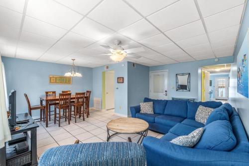 a living room with a blue couch and a table at The Treehouse On the Bay in Pensacola Beach