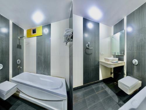 a bathroom with a tub and a toilet and a sink at Hotel Shivdev International, near New Delhi Railway Station & City Centre in New Delhi