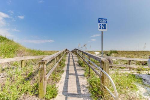 a speed limit sign next to a boardwalk on a beach at The Treehouse On the Bay in Pensacola Beach