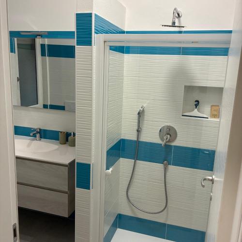 a bathroom with a shower with blue and white stripes at Bagaini Urban Flat in Varese