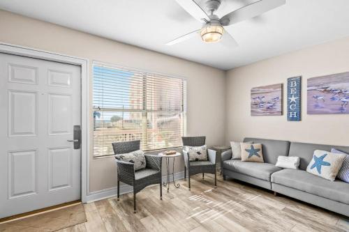 a living room with a couch and a table and chairs at Tropical Isle #205 in Fort Walton Beach