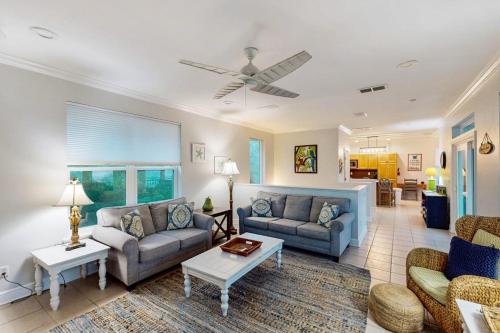 a living room with two couches and a table at Serenity Now in St. George Island