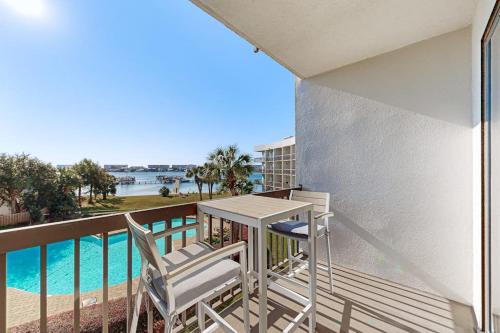 a balcony with two chairs and a table and a pool at Pirates Bay B314 in Fort Walton Beach