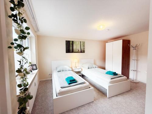 a bedroom with two beds and a refrigerator at Ferienwohnung Marie - WLAN, Küche, im Ortskern, Einkaufsläden in der Nähe in Malterdingen