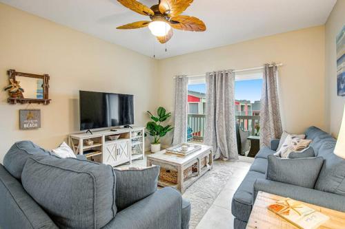 a living room with two blue couches and a television at Villas on the Gulf J6 in Pensacola Beach