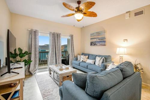 a living room with a blue couch and a tv at Villas on the Gulf J6 in Pensacola Beach