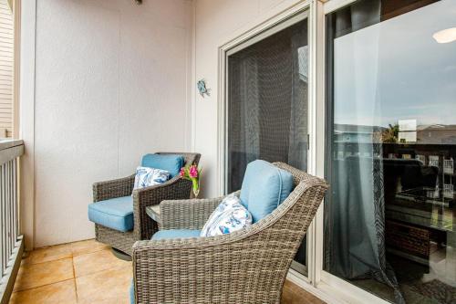 a balcony with two chairs and a window at Villas on the Gulf J6 in Pensacola Beach