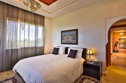 a bedroom with a large white bed and a window at Palais Amador in Oulad Mazoug