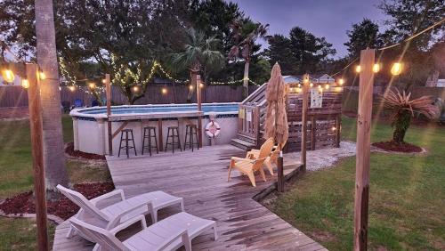 a deck with chairs and a swimming pool at night at Poolside Palms Paradise in Navarre