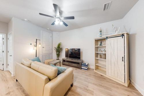 a living room with a couch and a ceiling fan at Windmark - Sea Grove Guesthouse in Saint Joe Beach