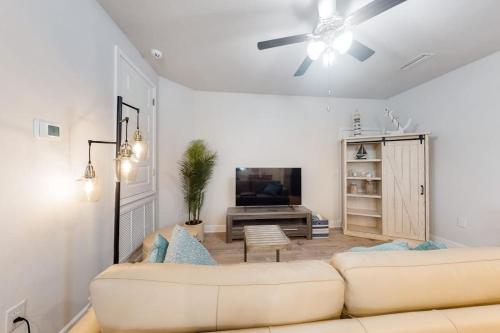 a living room with a couch and a flat screen tv at Windmark - Sea Grove Guesthouse in Saint Joe Beach