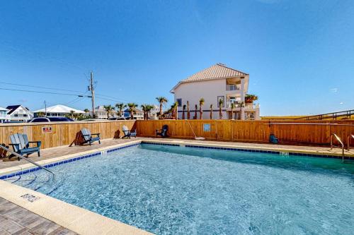 a swimming pool with two chairs and a house at Sundunes 121 in Navarre