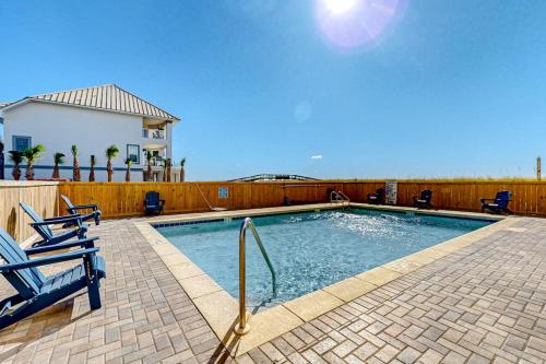 a swimming pool with two chairs and a fence at Sundunes 121 in Navarre