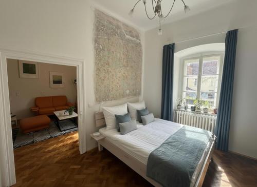 a bedroom with a bed and a chair and a window at Stadthotel Drosendorf - zum Goldenen Lamm - Failler in Drosendorf Altstadt