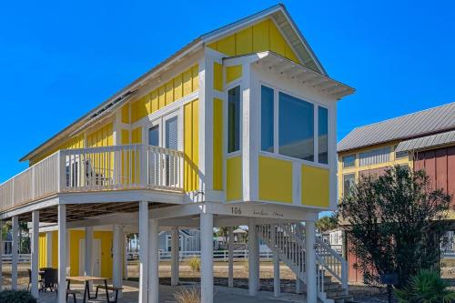 a yellow house with a porch and a deck at Sunshine Haven in Carrabelle