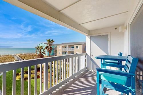 a balcony with a blue table and chairs and the ocean at Villas on the Gulf K-2 in Pensacola Beach