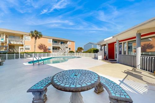 a patio with a table and a swimming pool at Villas on the Gulf K-2 in Pensacola Beach