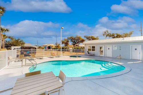a swimming pool with a bench and a building at Tranquil Harbour #211 in Mexico Beach