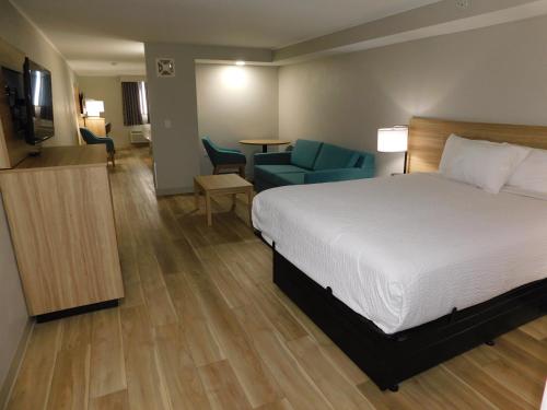 a hotel room with a bed and a living room at Days Inn by Wyndham Effingham in Effingham