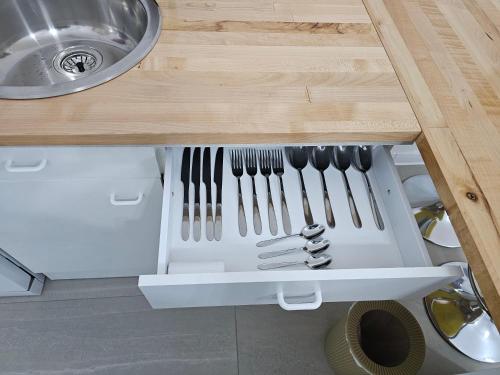 a drawer in a kitchen with forks and knives at Studio M in Năsăud