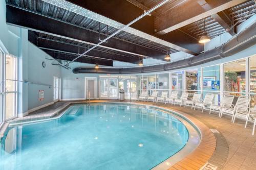 a swimming pool with chairs in a building at Pelican Beach Resort 502 in Destin