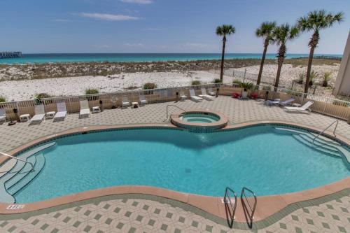 a swimming pool with chairs and the beach at Inn at Summerwind 0602 in Navarre