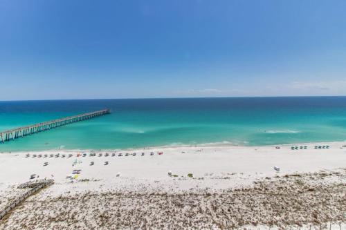 a beach with a pier and a group of people at Inn at Summerwind 0602 in Navarre