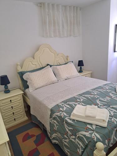 a bedroom with a bed and a night stand with two lamps at Casa da Miquinhas II in Ponte da Barca