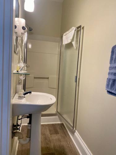 a white bathroom with a shower and a sink at Red Rose Inn Bed and Breakfast in Bardstown