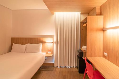a hotel room with a bed and a desk and a bed sidx sidx sidx sidx at Hotel Moov Porto Alegre in Porto Alegre