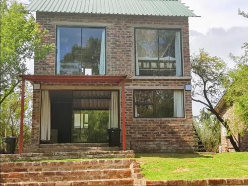a brick house with a green roof at Bloemhof Riverside Chalets in Bloemhof