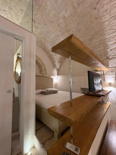 a bedroom with a bed and a desk with a television at La Piazzetta - Luxury Homes in Ceglie Messapica