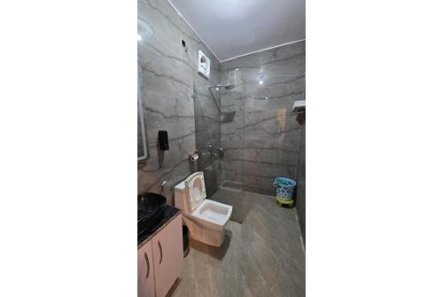 a bathroom with a white toilet and a shower at Hushvan Resorts in Devaprayāg