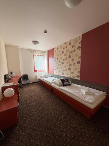 a hotel room with two beds and a desk at Hotel Galaxie in Zlín