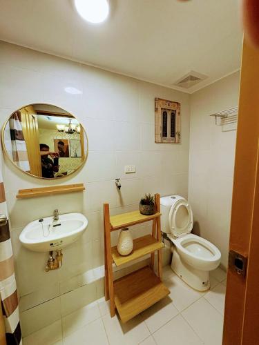 a bathroom with a toilet and a sink and a mirror at 727 Anabelle Residence at Marina Spatial Condominium in Dumaguete