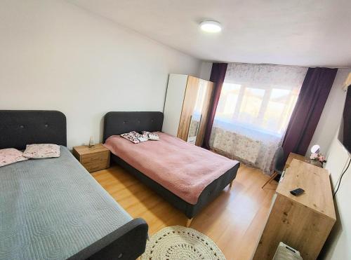 a small bedroom with two beds and a window at Cuibul Practic in Oradea