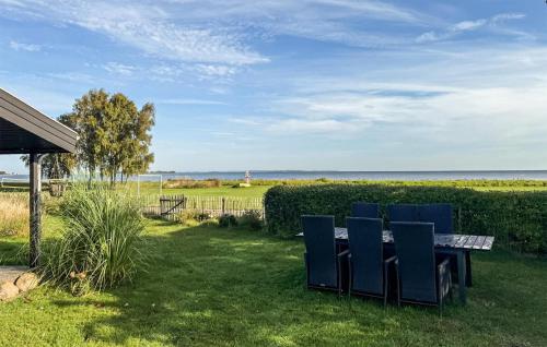 a table and chairs in a yard with a view of the ocean at 2 Bedroom Cozy Home In Askø in Askø