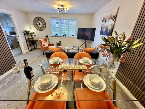 a living room with a glass table and orange chairs at No56 - 2-bed Boutique Apartment - Hosted by Hutch Lifestyle in Leamington Spa