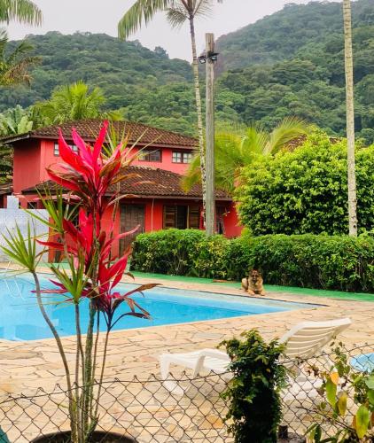a resort with a swimming pool and a red house at Chales Terra Pura in Camburi