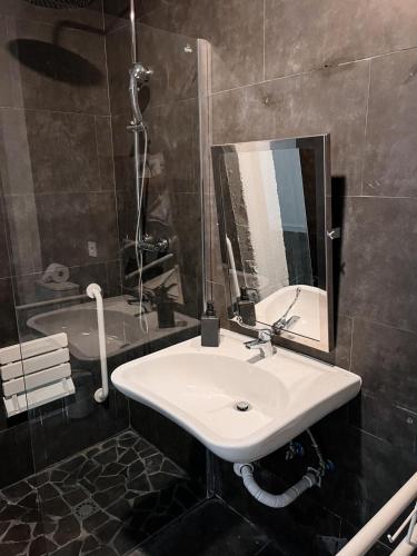 a bathroom with a sink and a mirror and a tub at Cozy Room G10 in Valencia